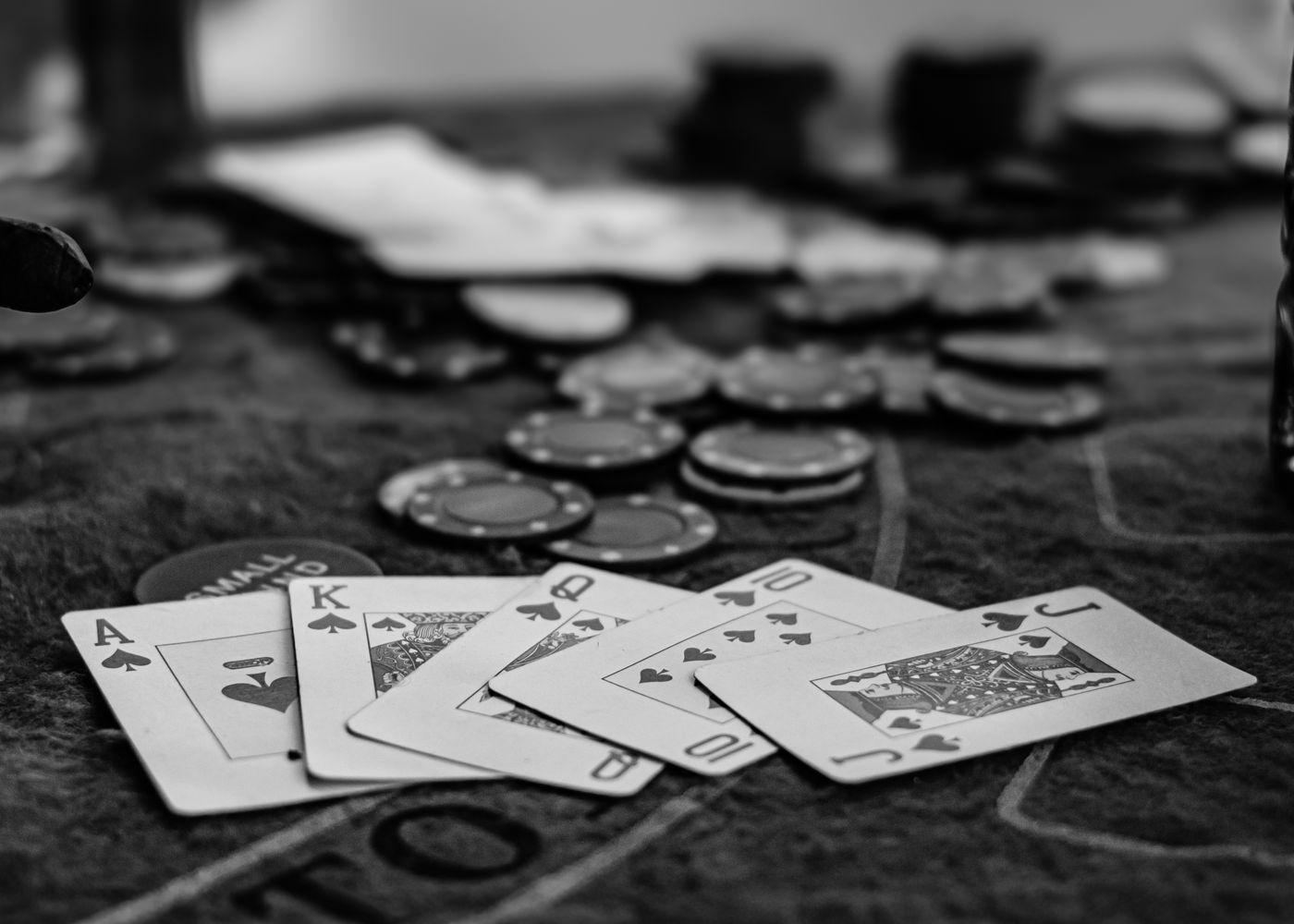 Kartu remi dan chip poker di atas meja kasino